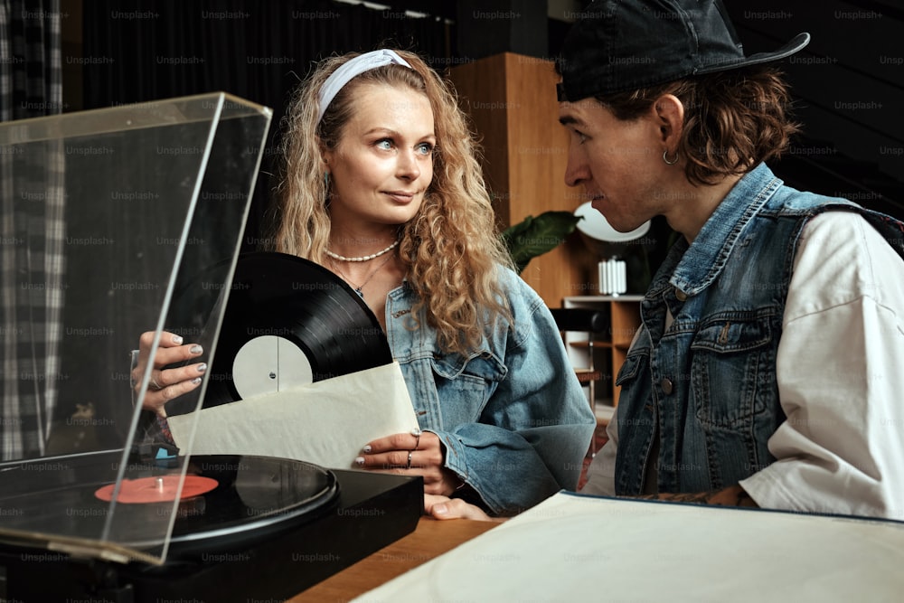 Un hombre y una mujer mirando un tocadiscos