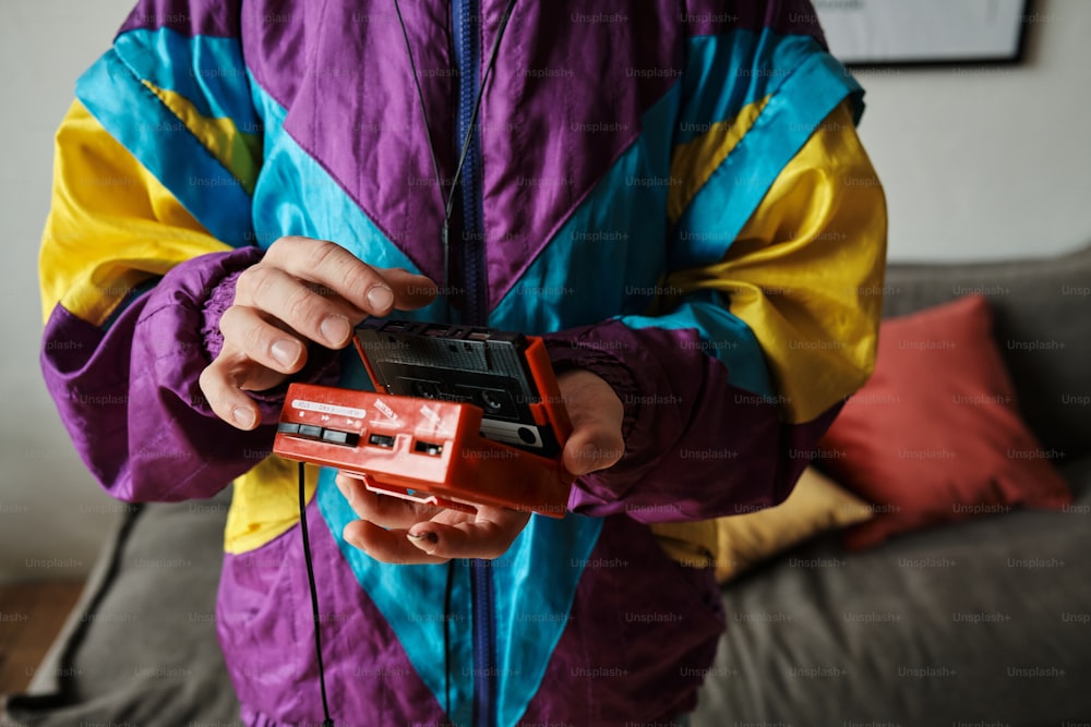 uma pessoa em uma jaqueta colorida segurando um telefone celular