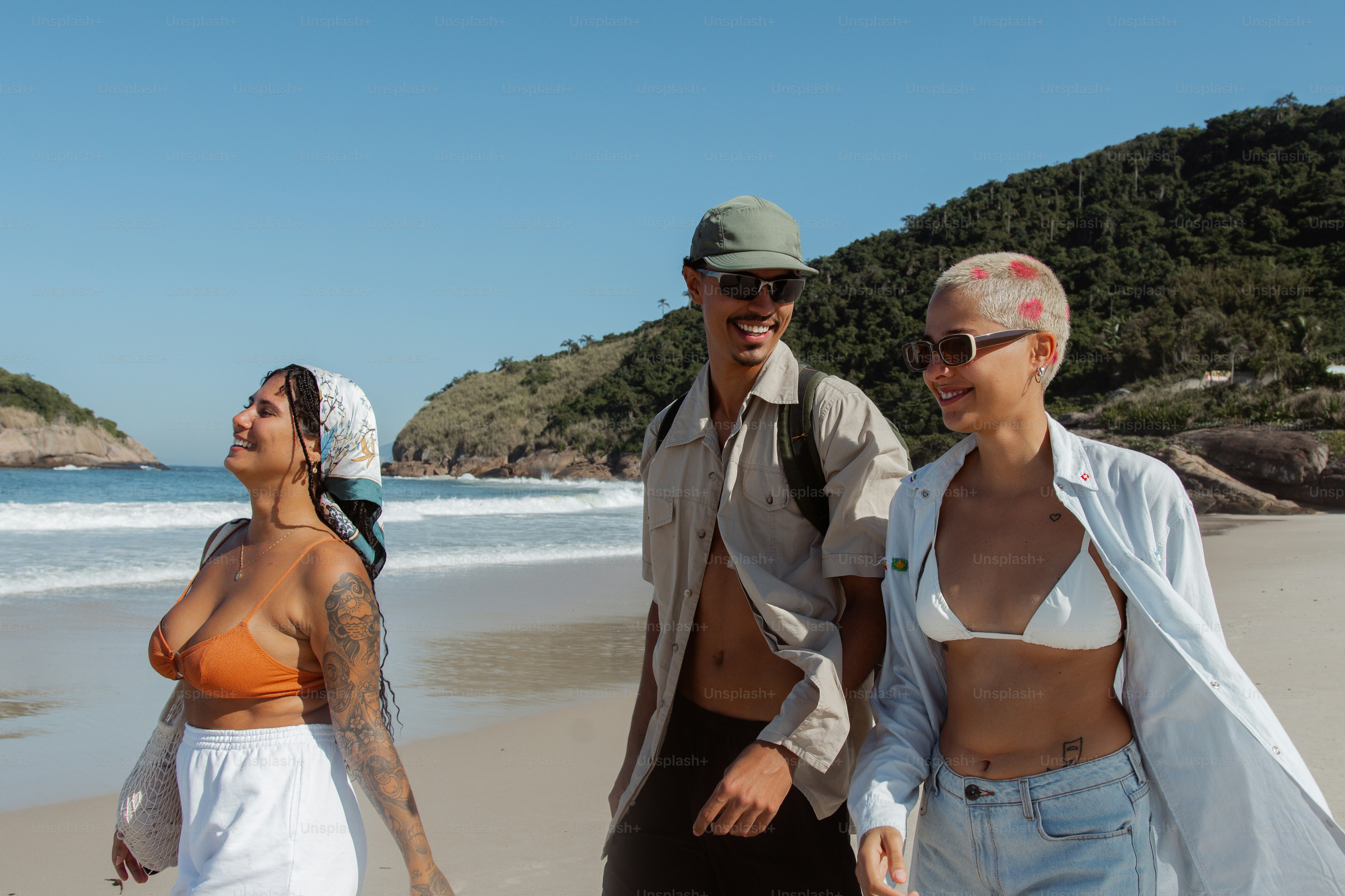 Un grupo de personas de pie en la cima de una playa de arena