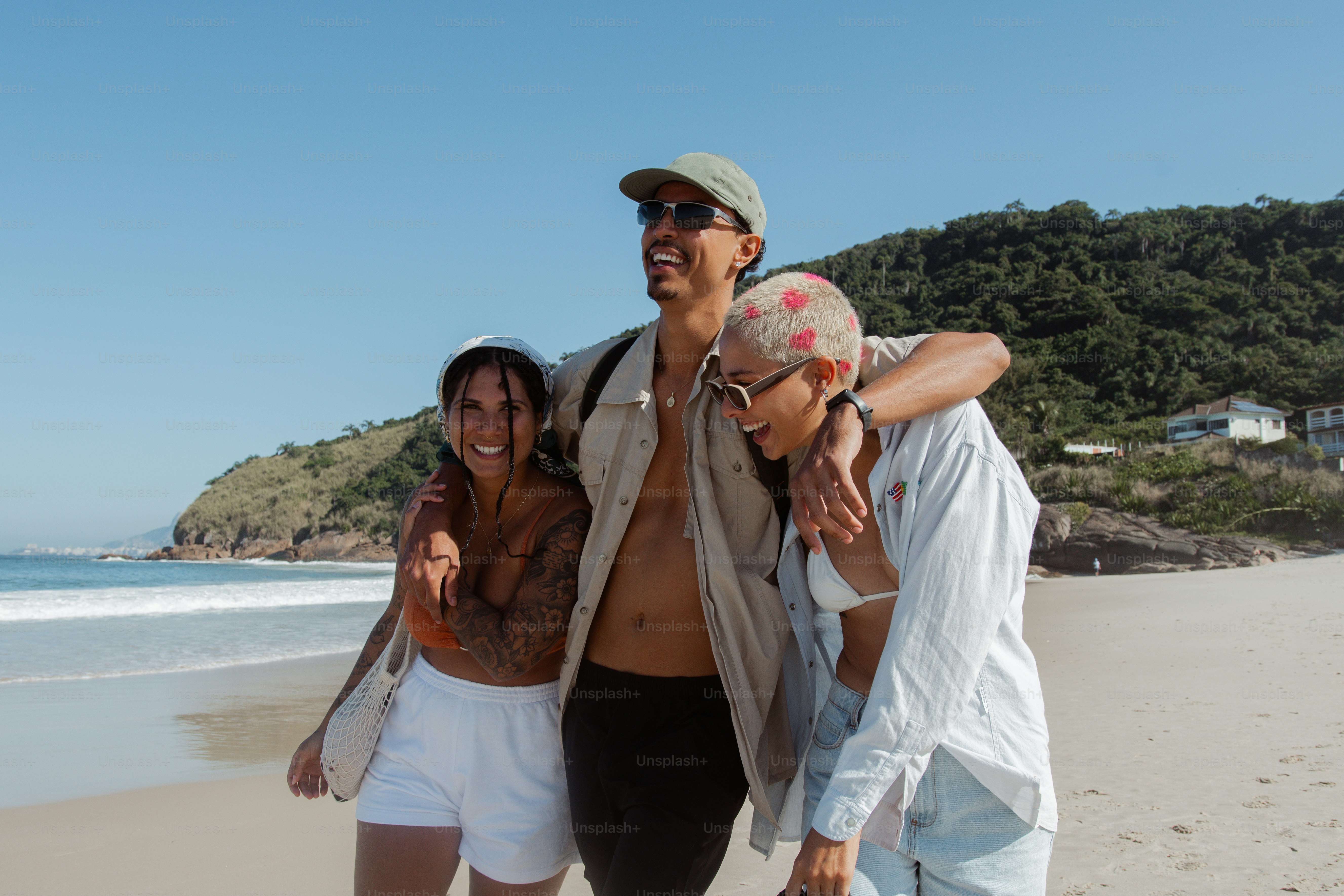 ein mann und zwei frauen, die an einem strand stehen
