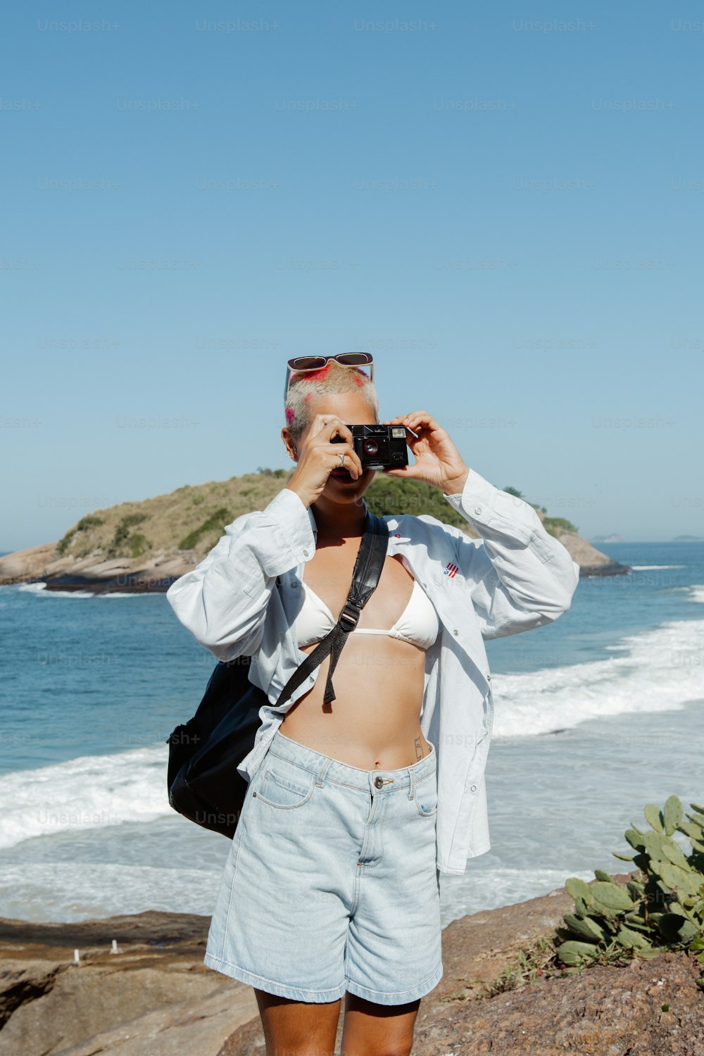 携帯電話で海の写真を撮る女性