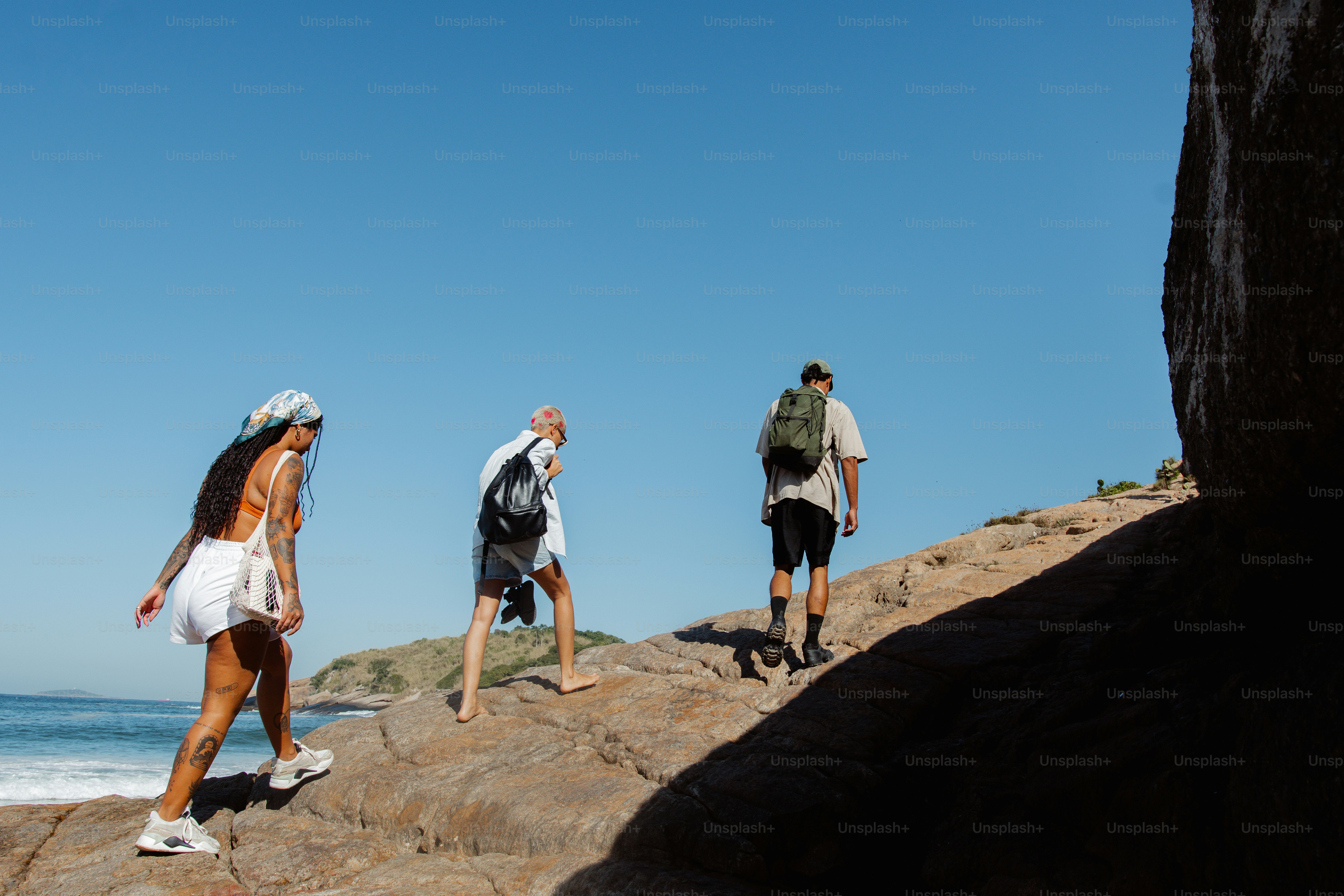 Eine Gruppe von Menschen, die an einem felsigen Strand spazieren gehen