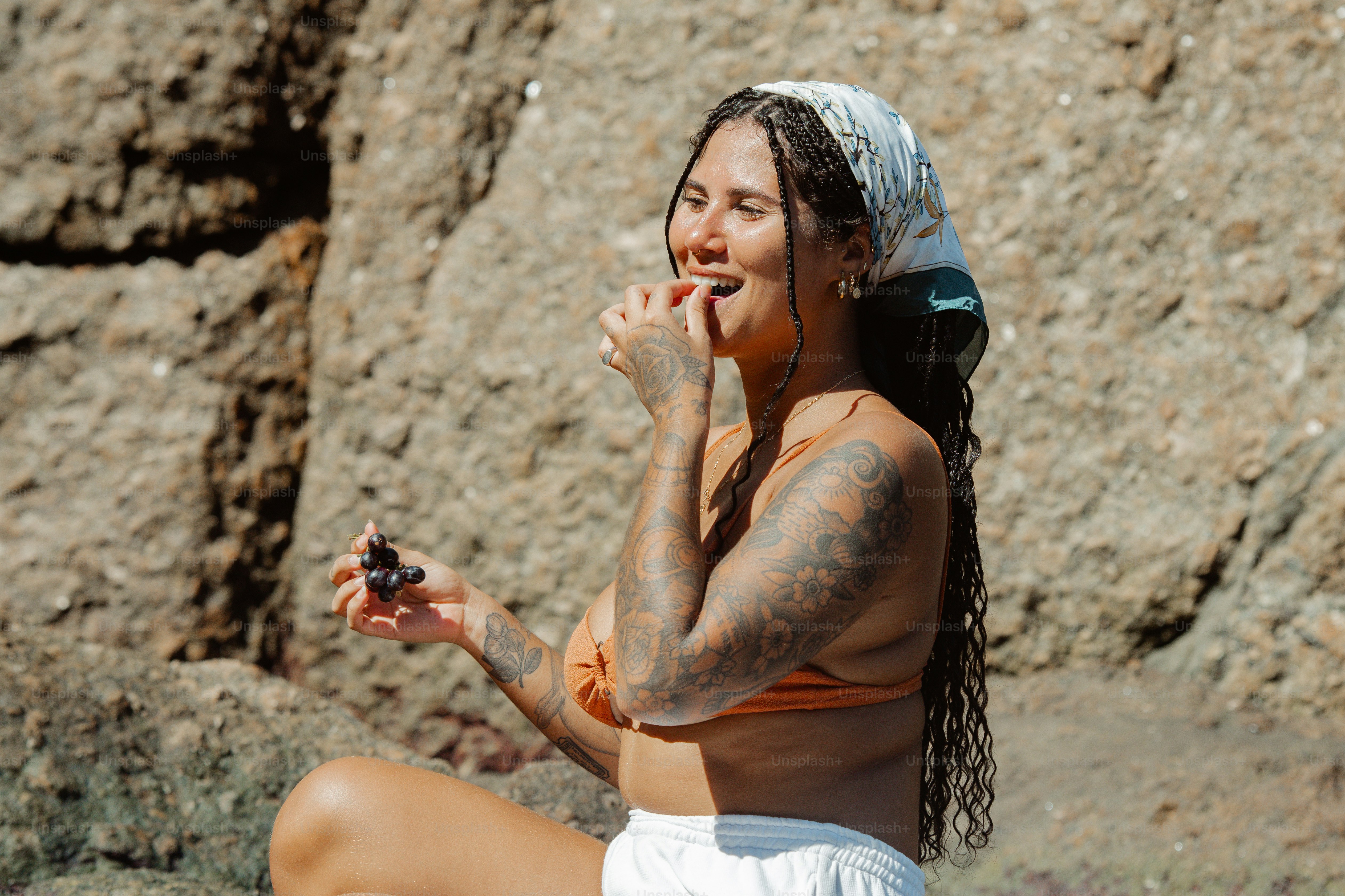 Una mujer sentada en una roca comiendo algo