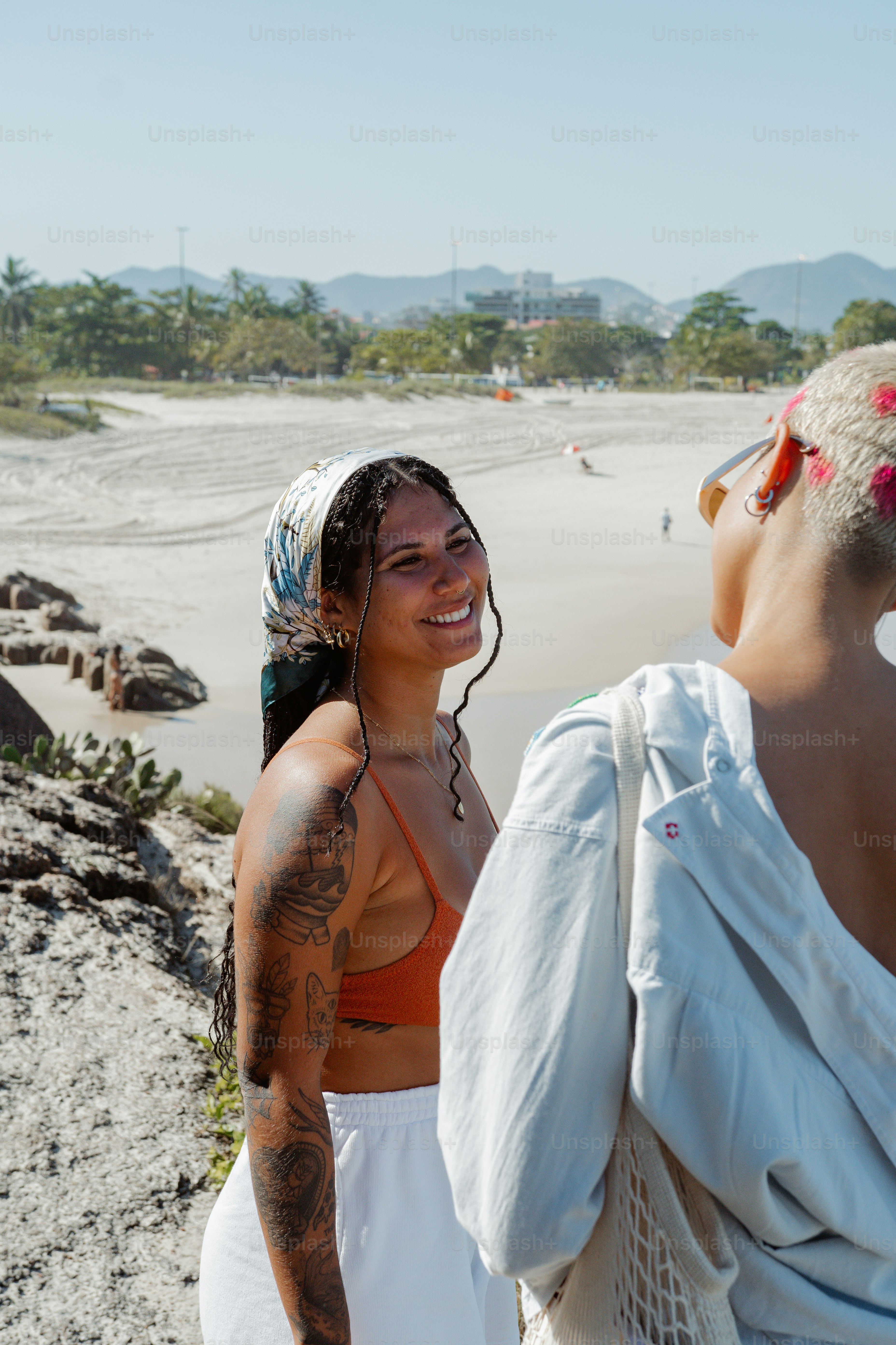 a couple of women standing next to each other on a beach