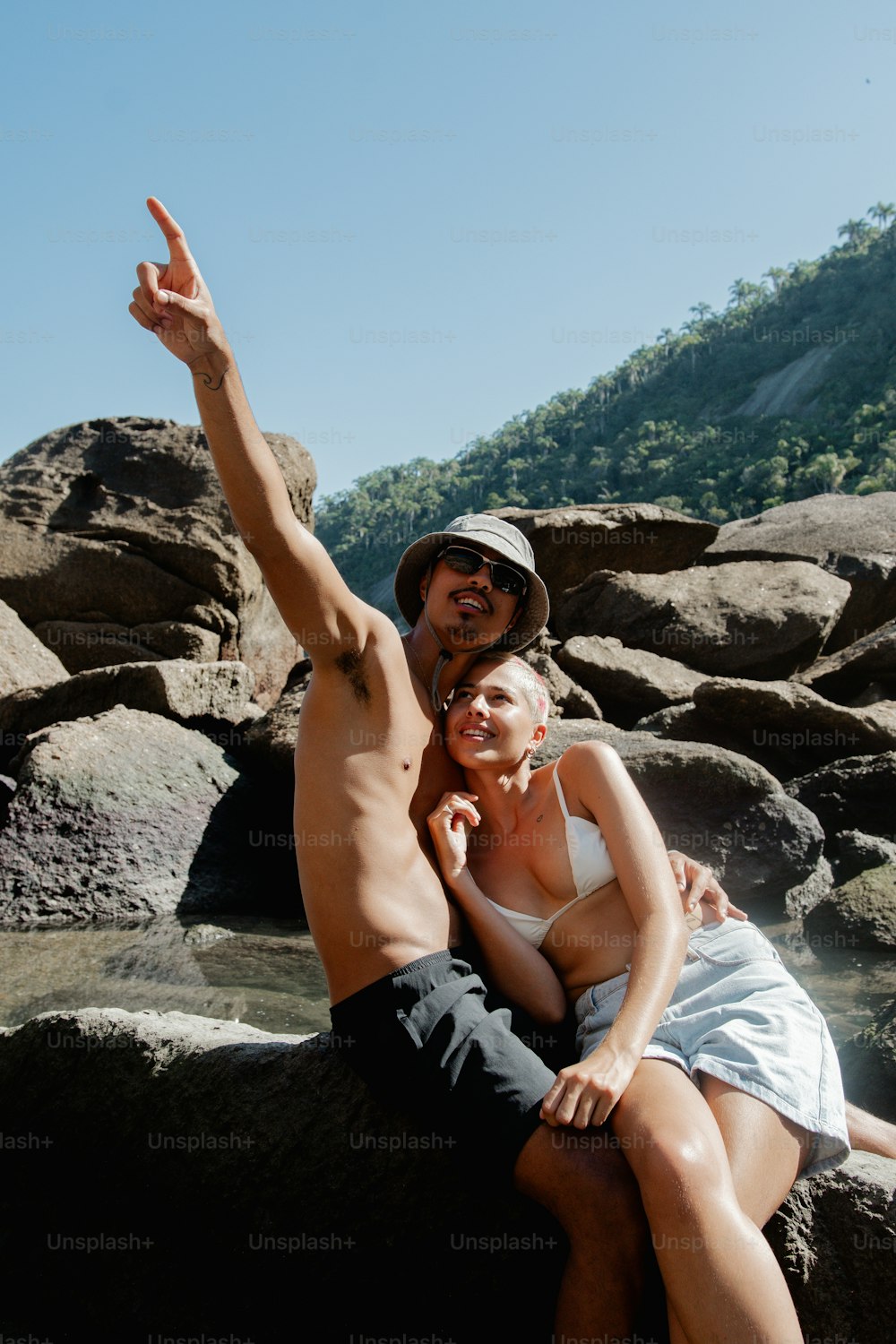 a man and a woman are sitting on a rock