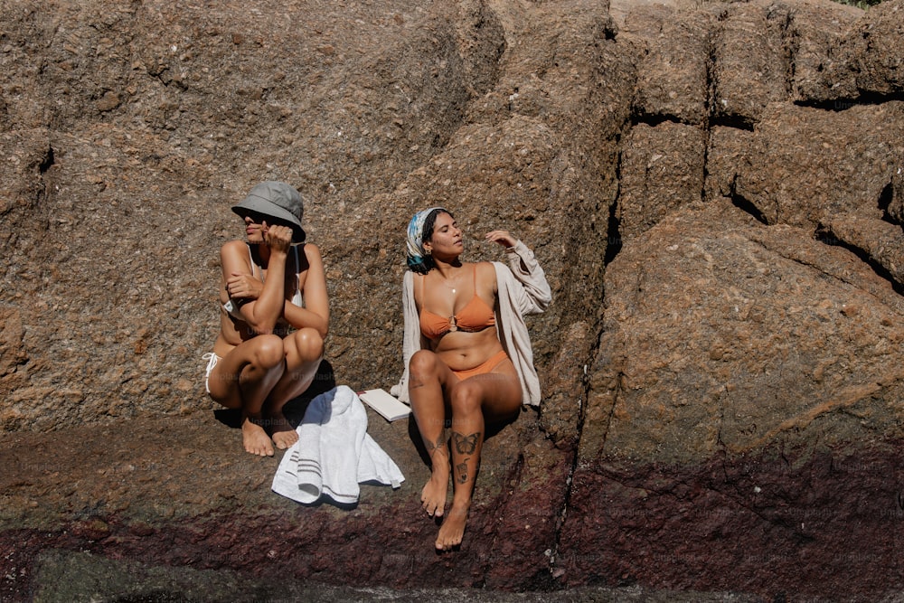 una coppia di donne sedute una accanto all'altra su una spiaggia