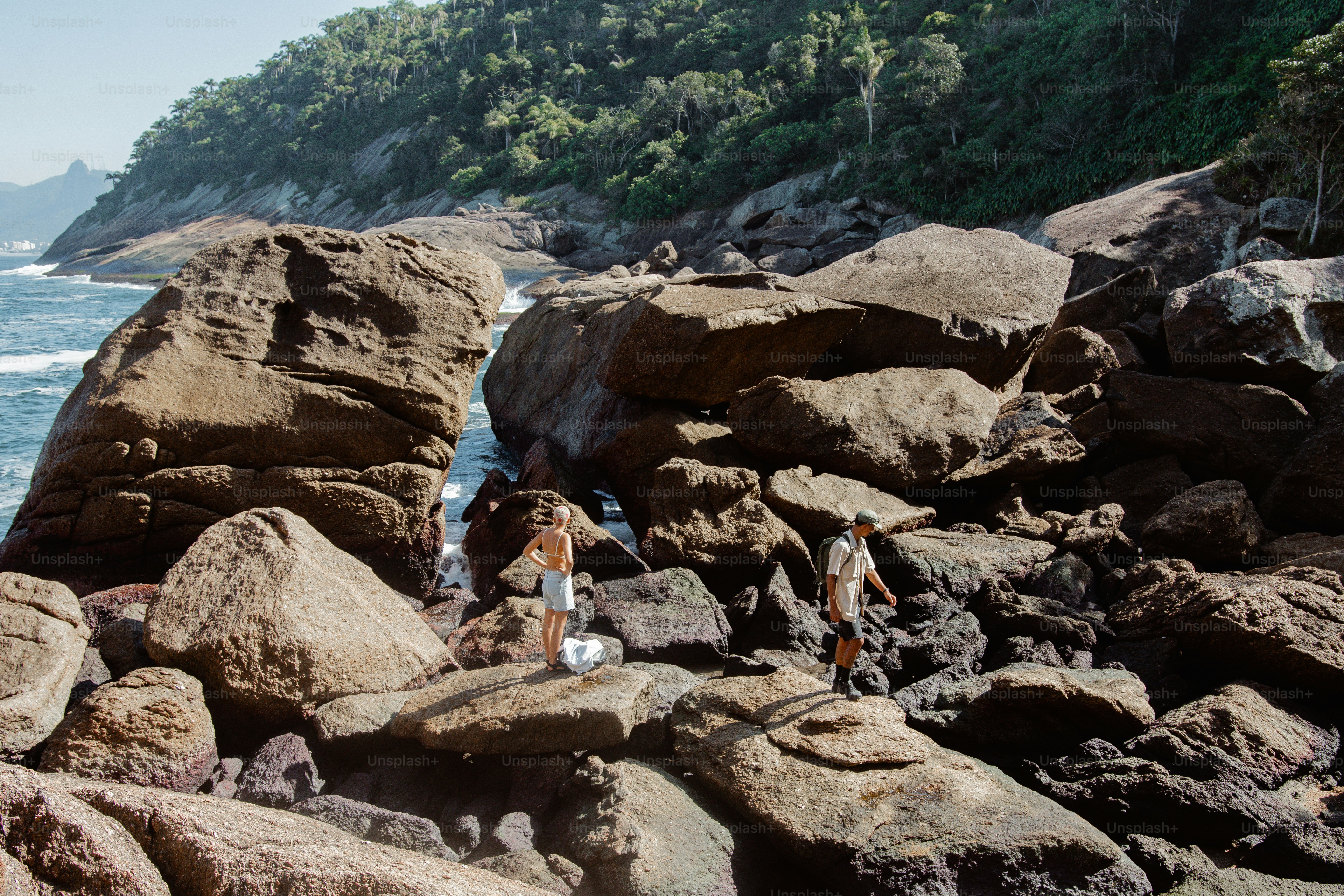 Un grupo de personas de pie en la cima de una playa rocosa