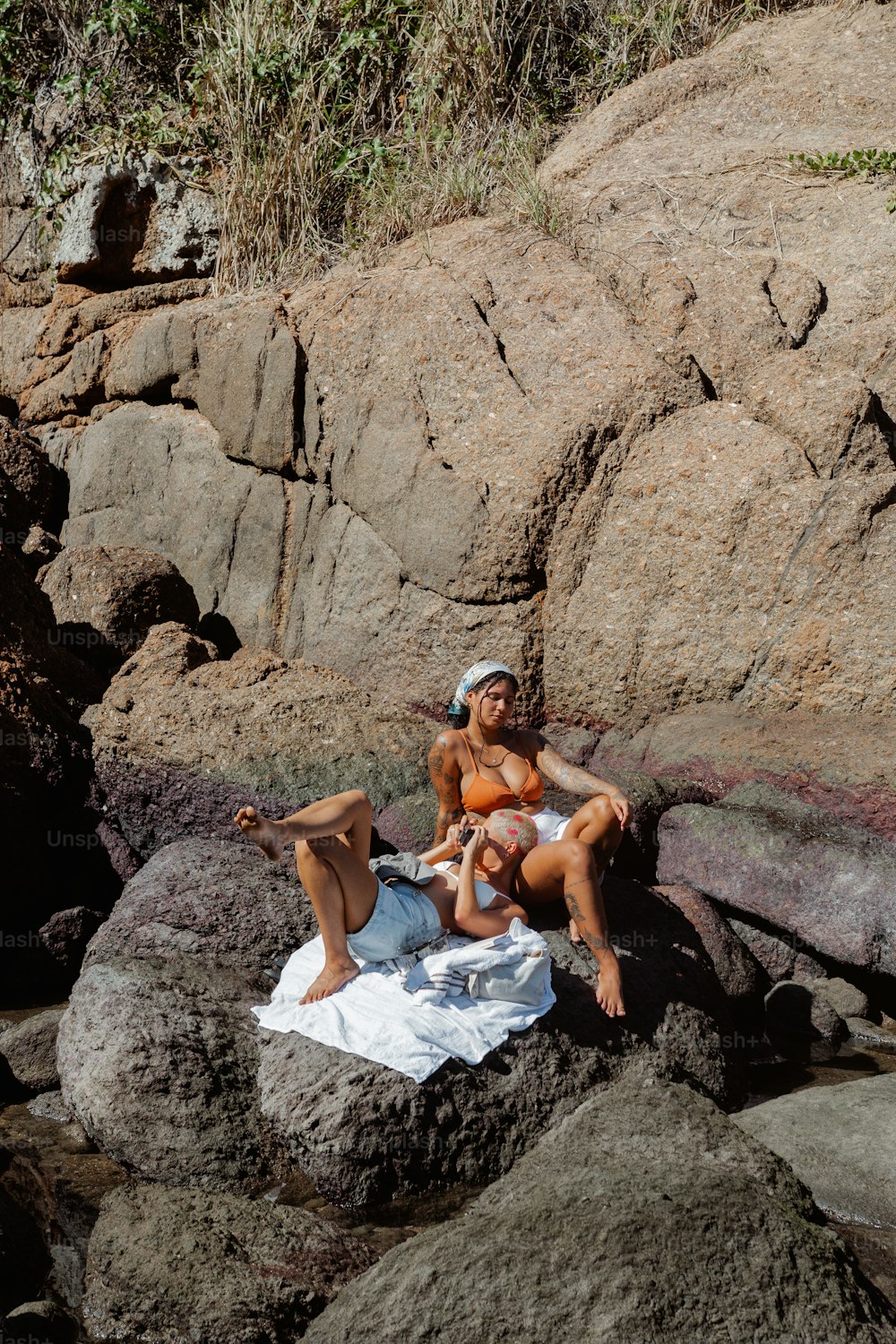 a couple of women sitting on top of rocks