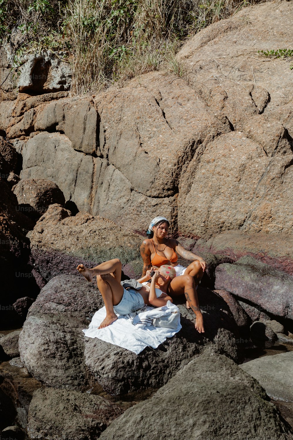 岩の上に座っている女性のカップル