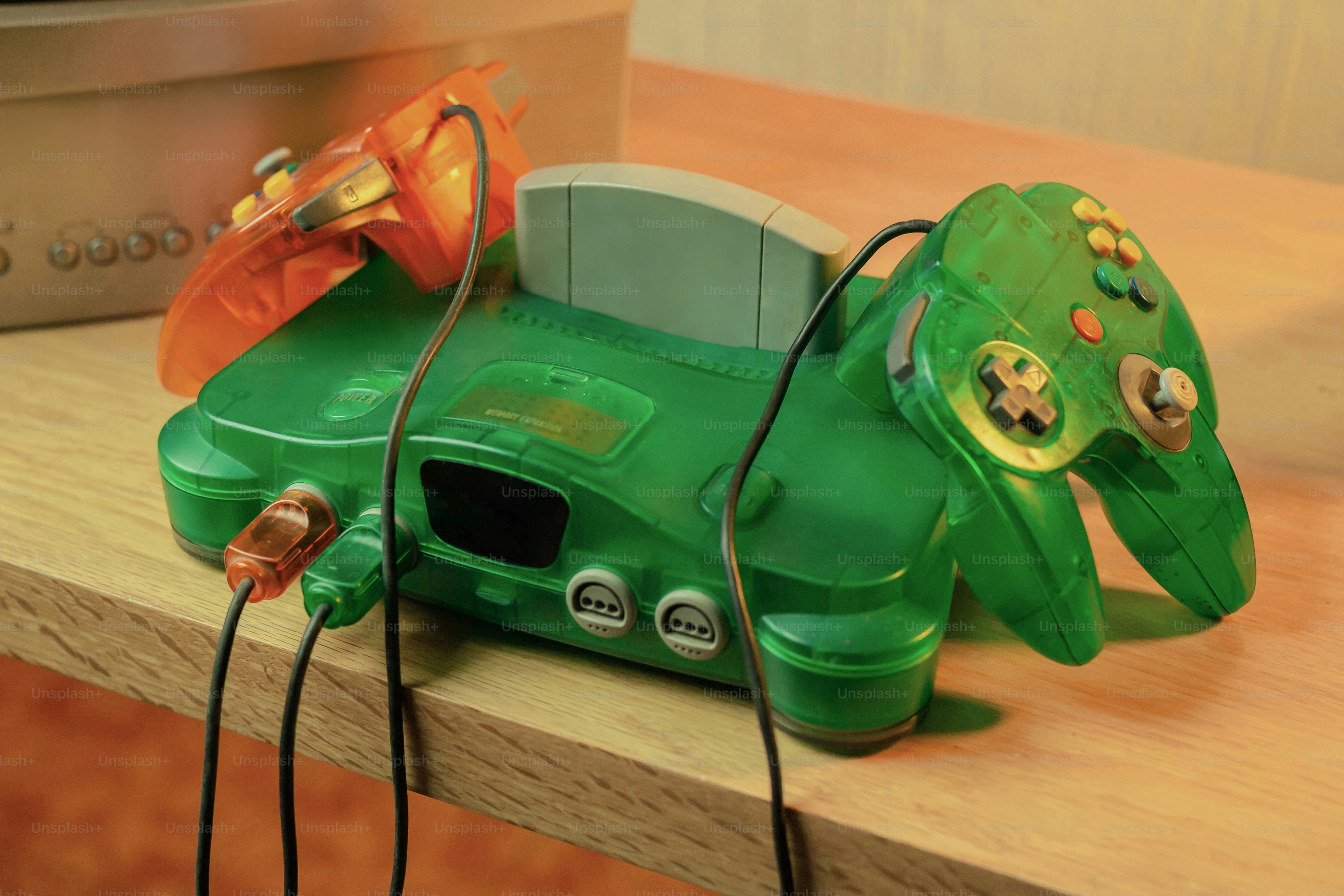 A video game controller sitting on top of a wooden table photo – 90s ...