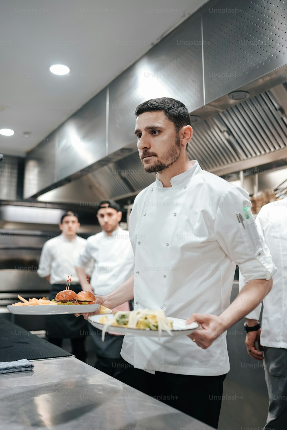 a man holding a plate of food in a kitchen