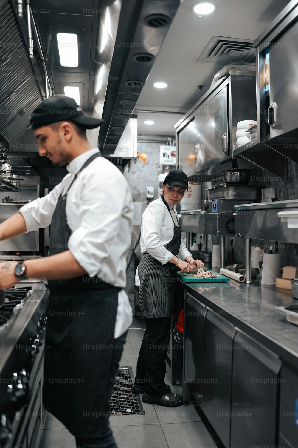 two chefs in a commercial kitchen preparing food