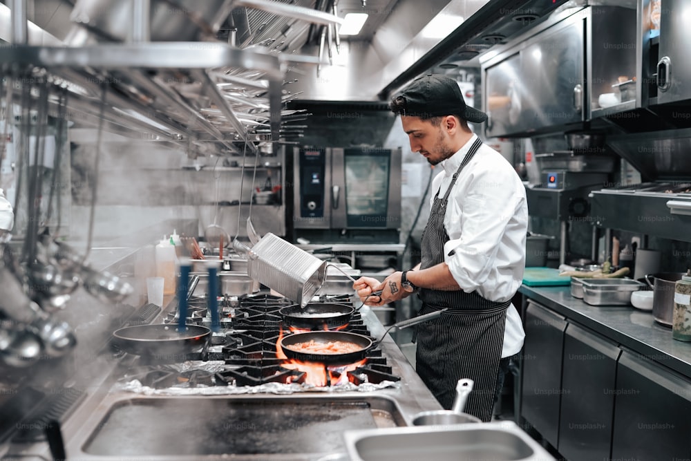 um homem em uma cozinha preparando comida em cima de um fogão