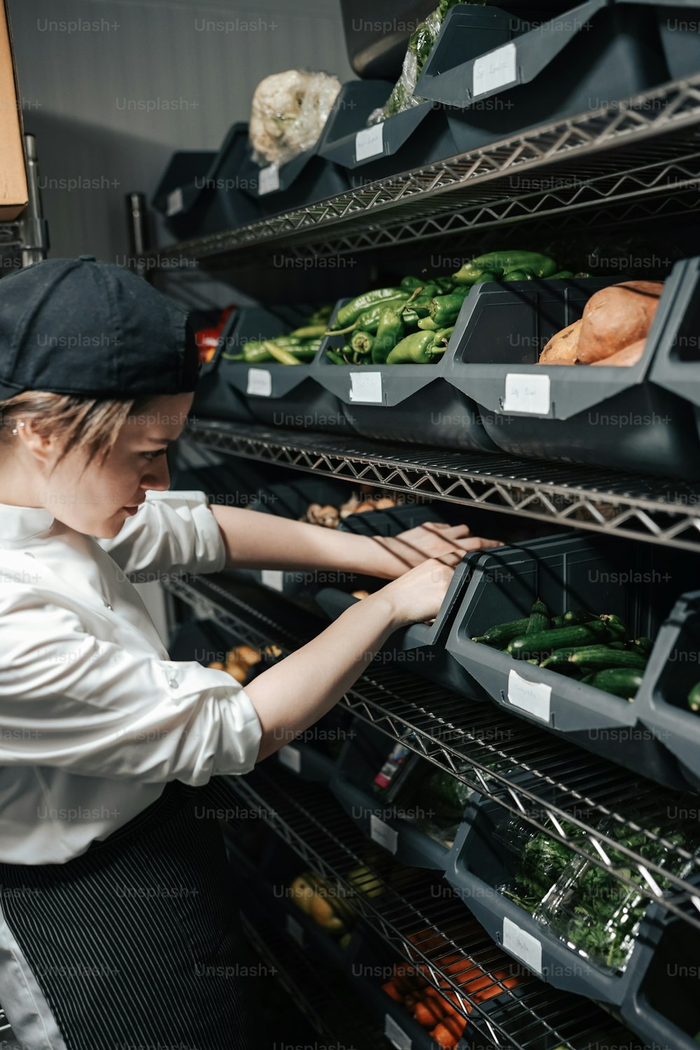 a woman looking at a rack of vegetables