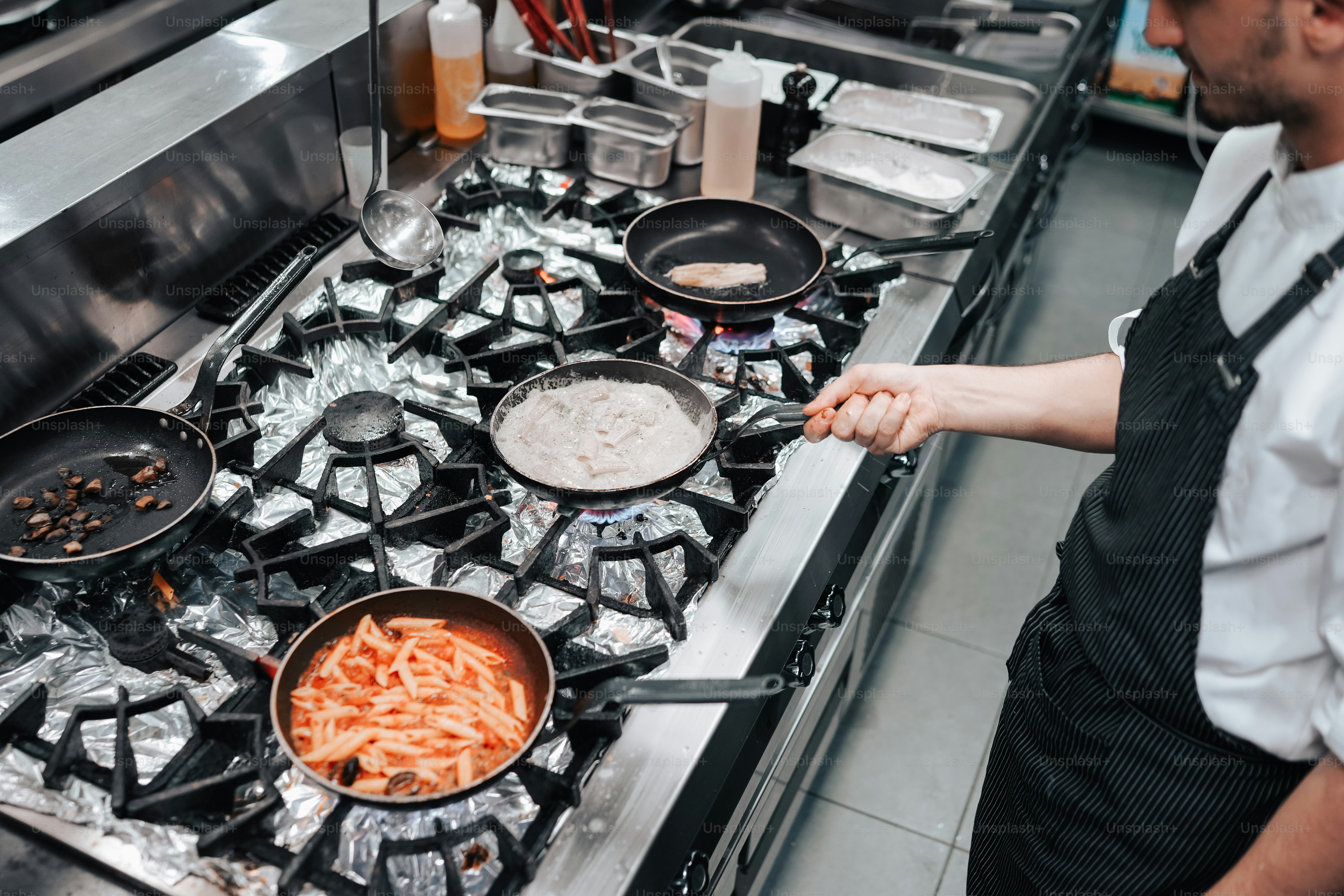 a man in a kitchen cooking food on a stove