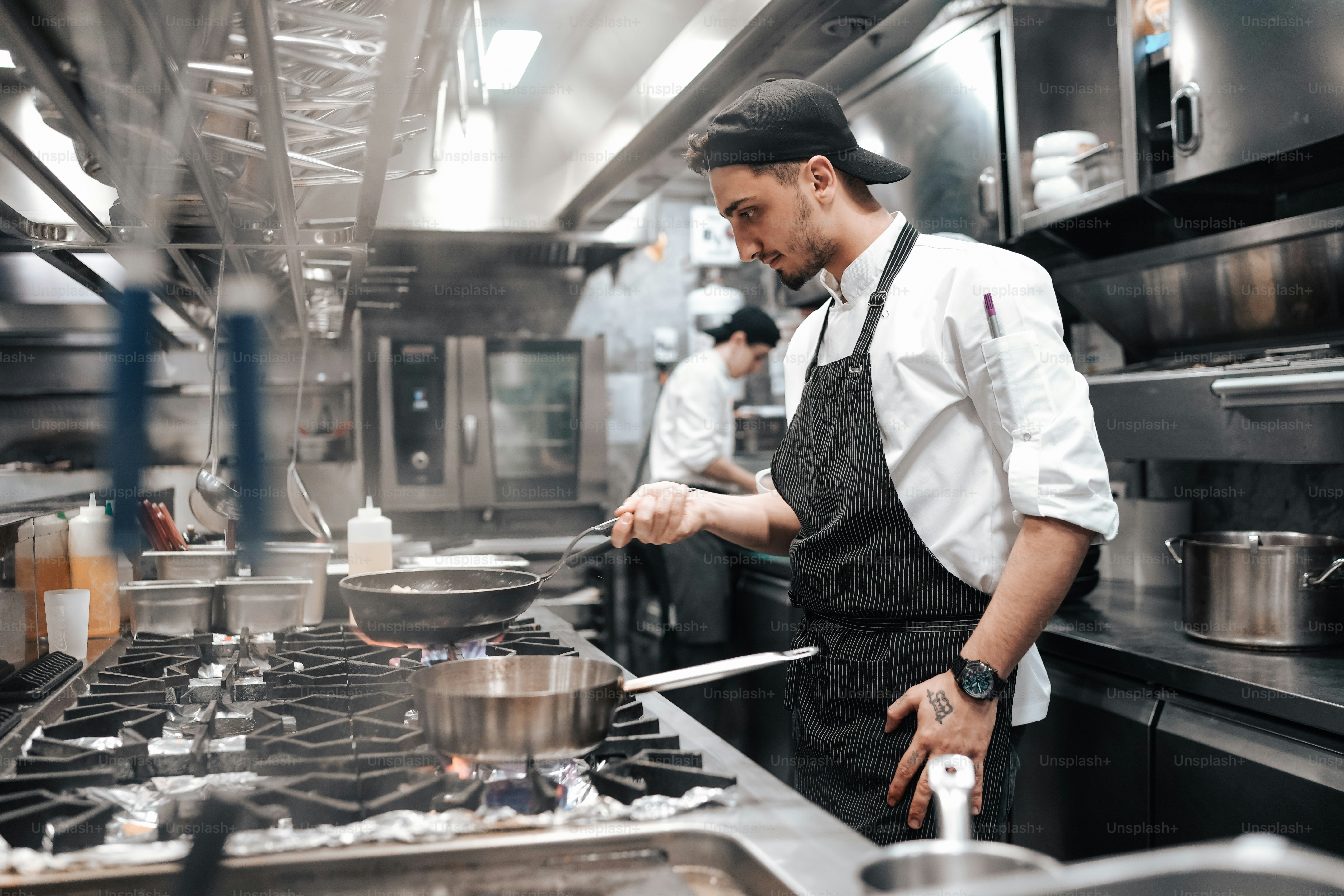 a man is cooking in a large kitchen