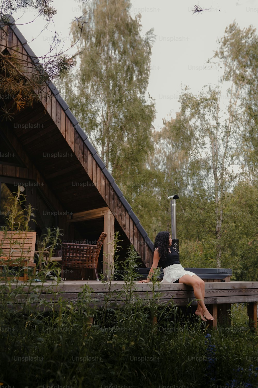 una donna seduta su un ponte con una valigia