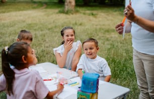 a group of children sitting around a table