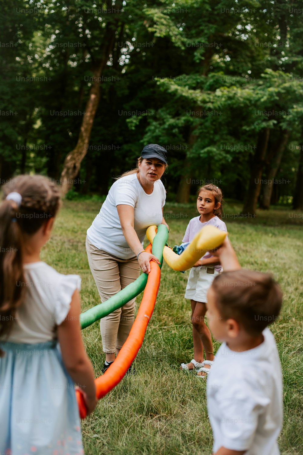 Una mujer y dos niños jugando con un tubo inflable