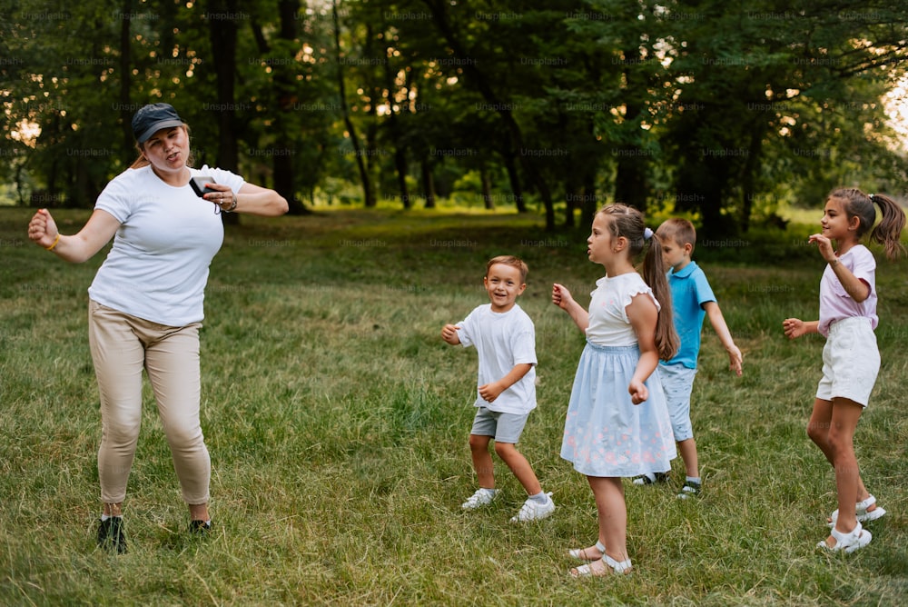 a woman standing in a field with a group of children