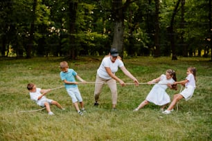 Un hombre tirando de un grupo de niños en una cuerda