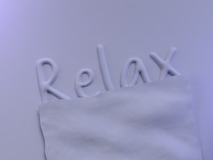 a close up of a piece of paper with the word relax on it