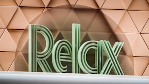 a close up of the word relax on a wall