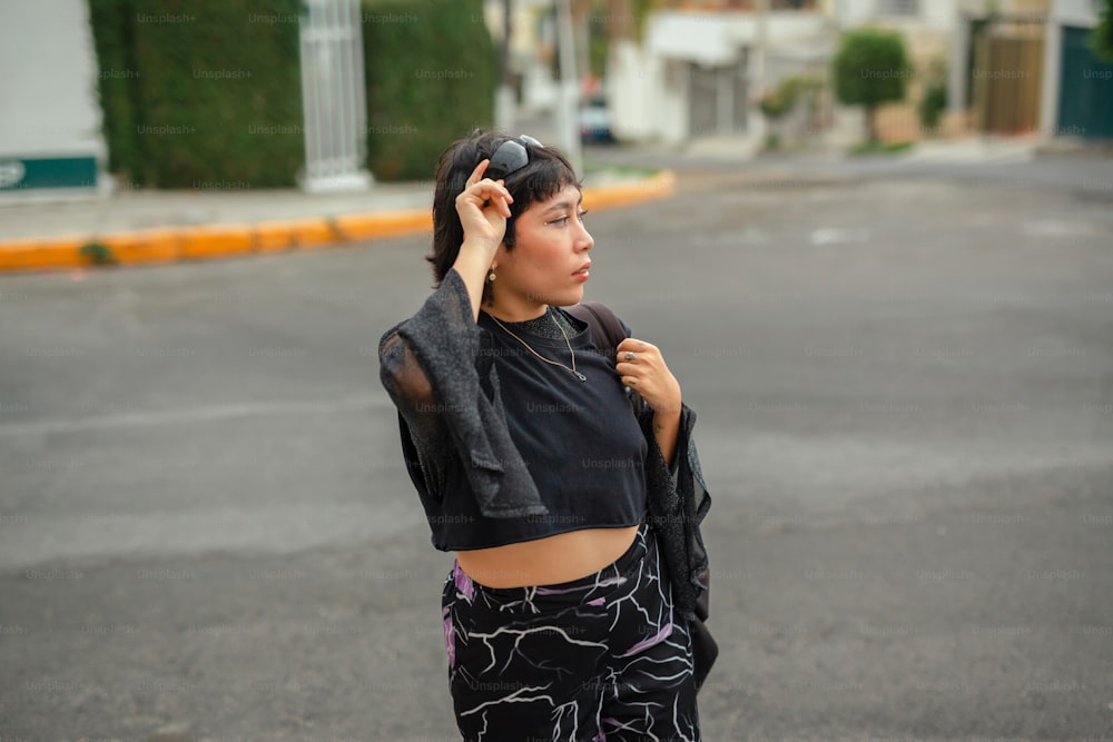 a woman in a black top is holding a jacket over her head