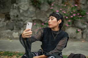 uma mulher sentada no chão segurando um celular