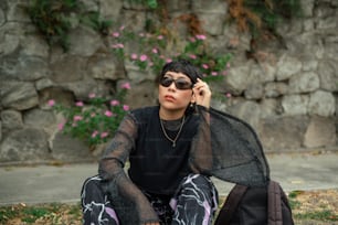 a woman sitting on the ground talking on a cell phone