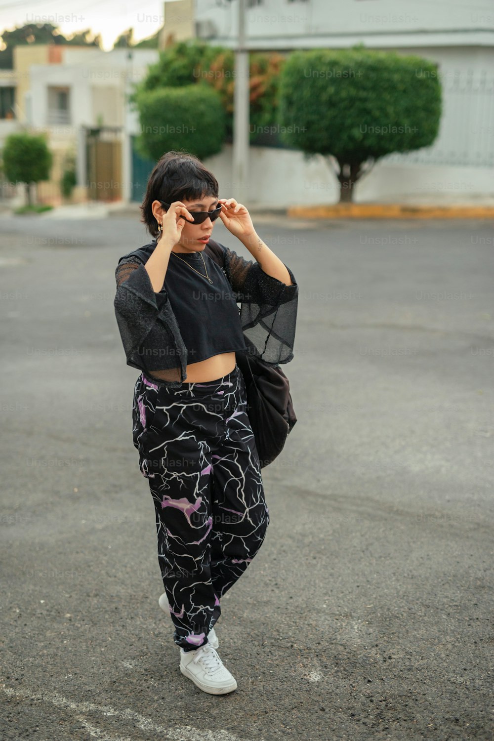 a woman in a black crop top and patterned pants
