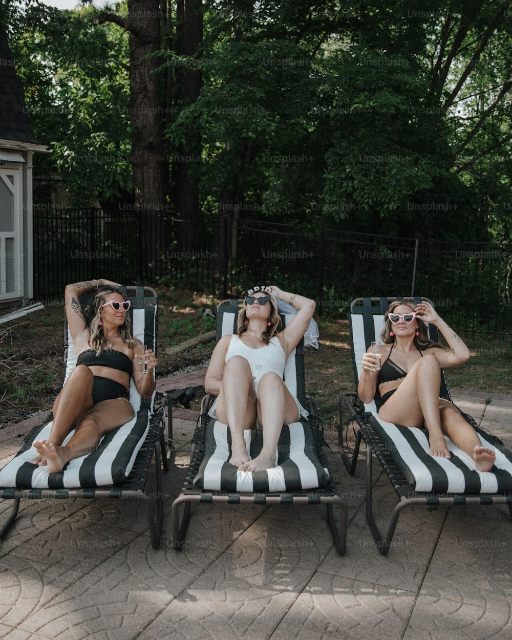 three women in bathing suits lounging on lounge chairs