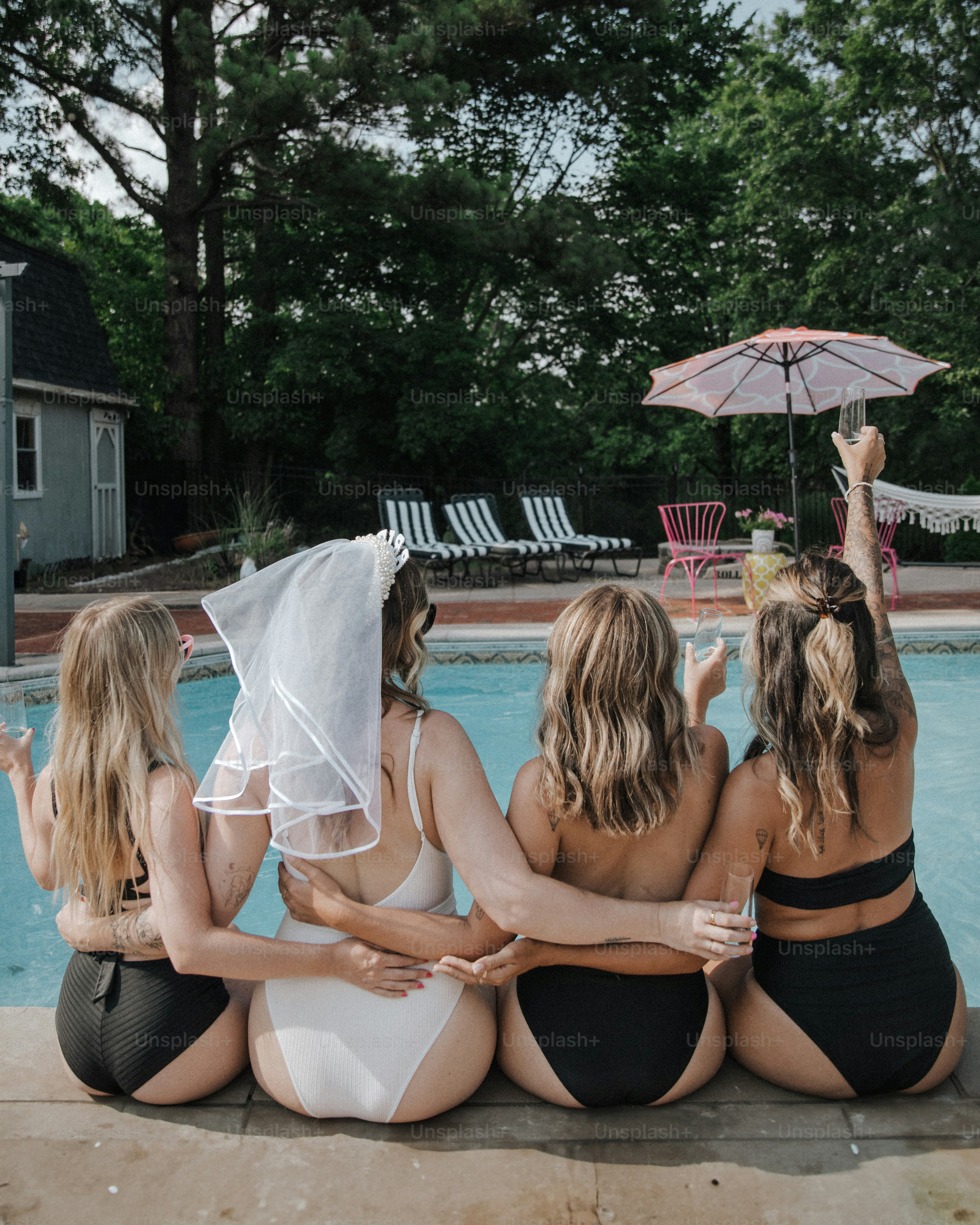 a group of women sitting next to a swimming pool