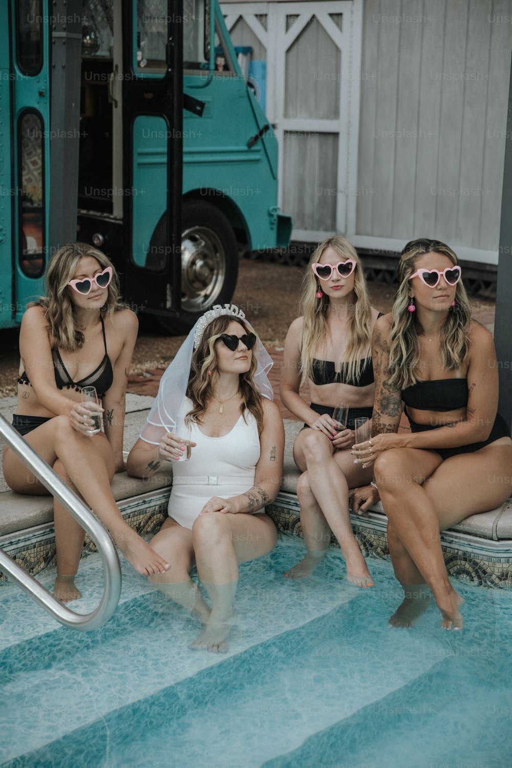 a group of women sitting next to each other near a pool