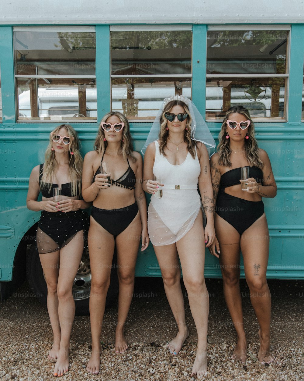 a group of women standing next to a blue bus