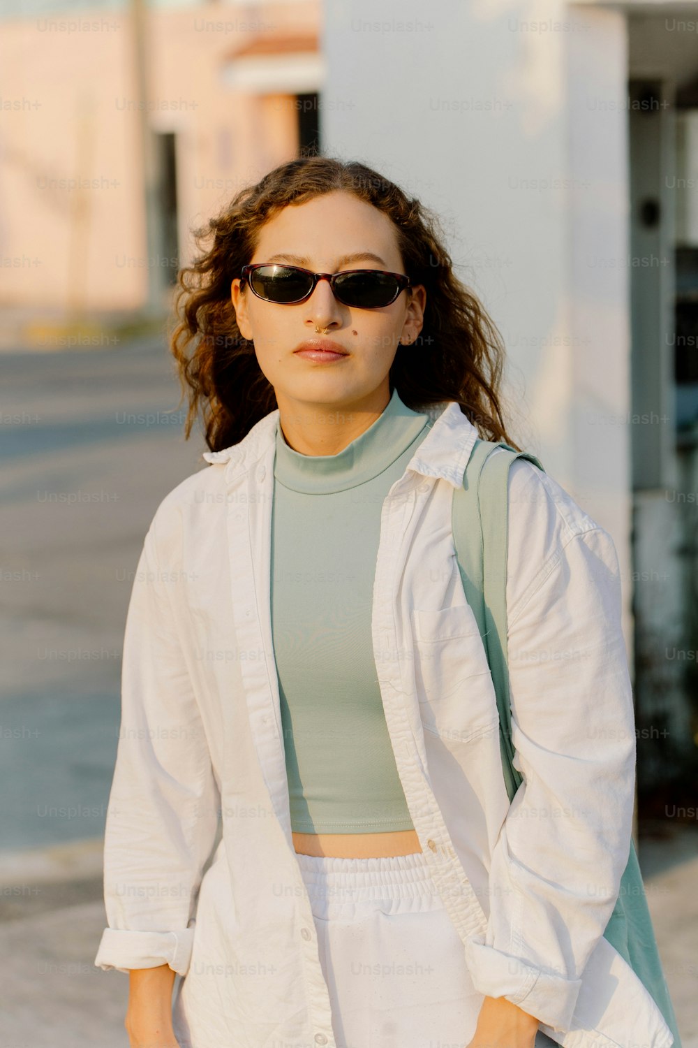 Eine Frau mit Sonnenbrille und weißer Jacke