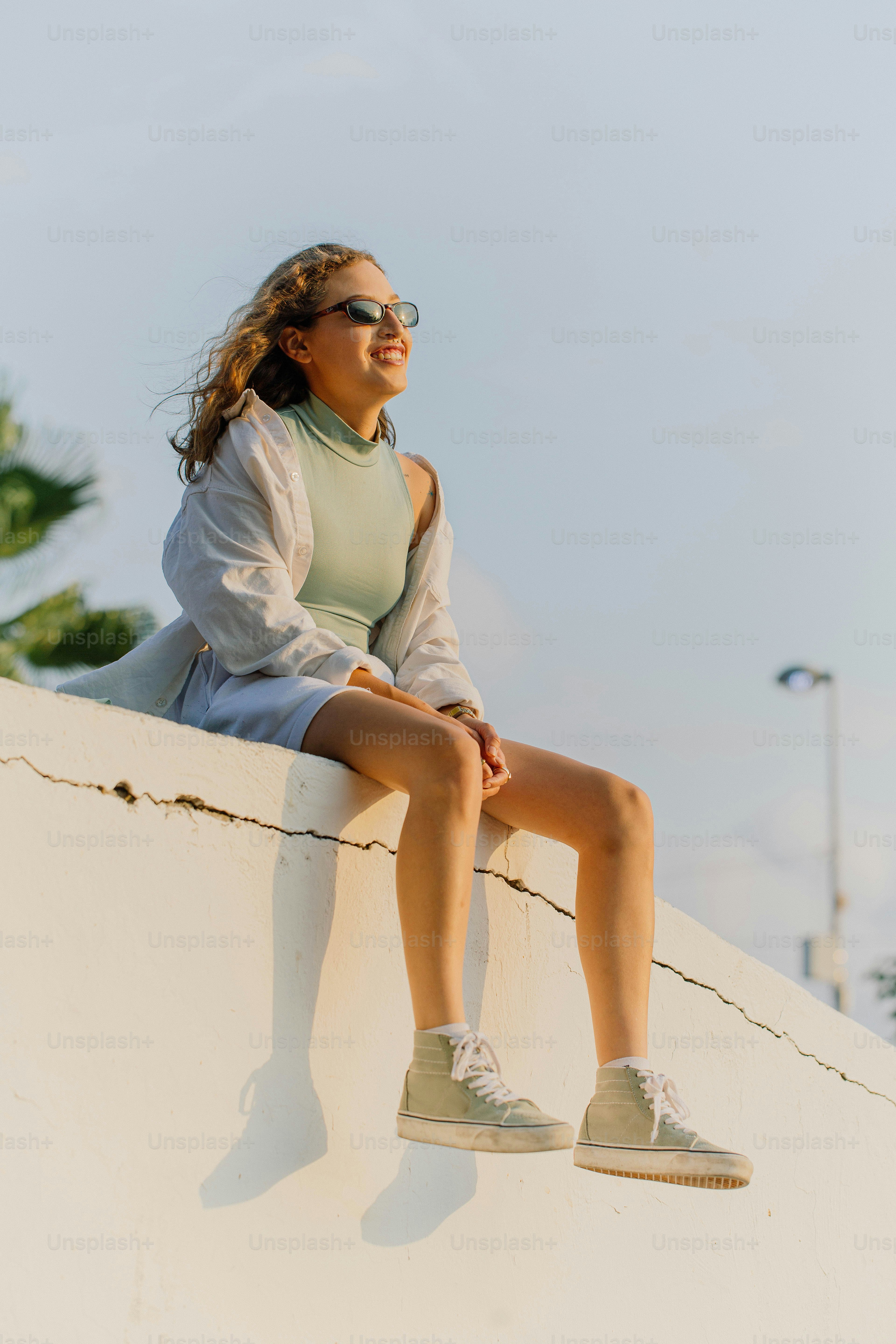 흰 벽 위에 앉아 있는 여자