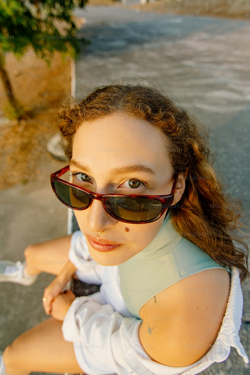 a woman wearing sunglasses sitting on a bench