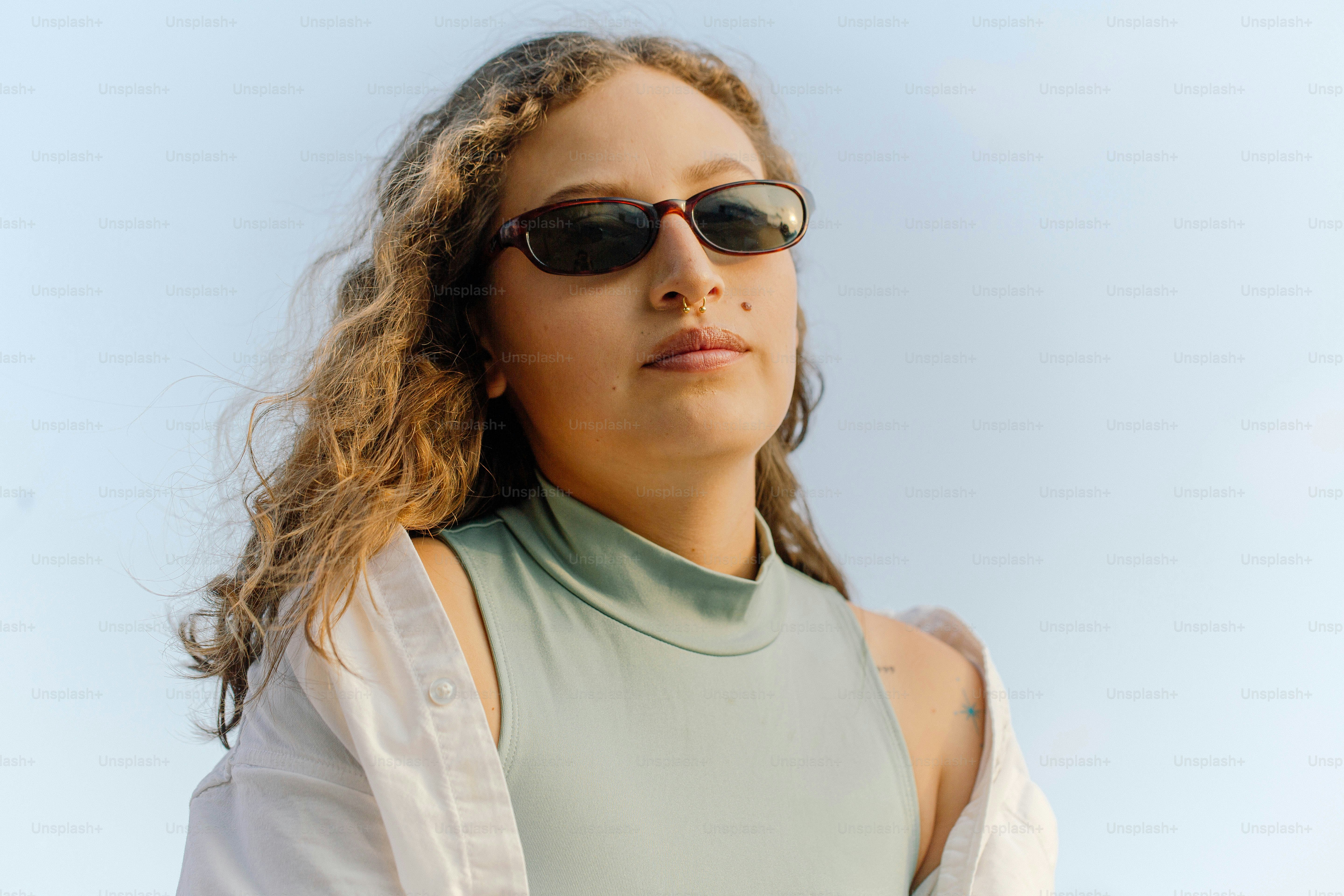 a woman wearing sunglasses and a green shirt