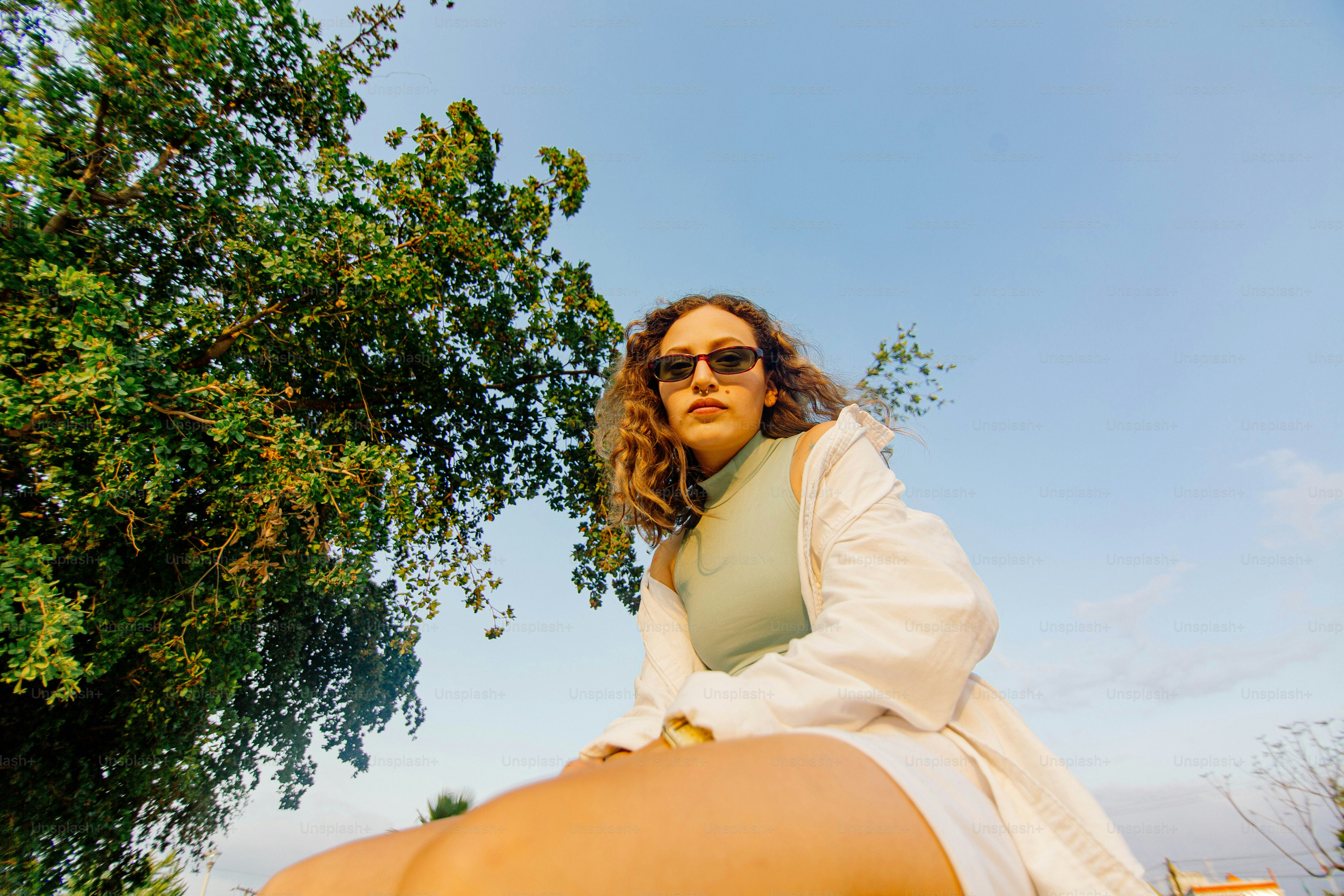 a woman in a white dress sitting on a tree