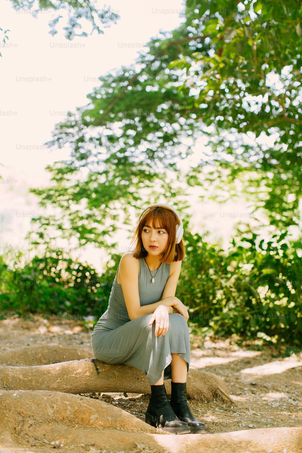 a woman sitting on a rock in a forest