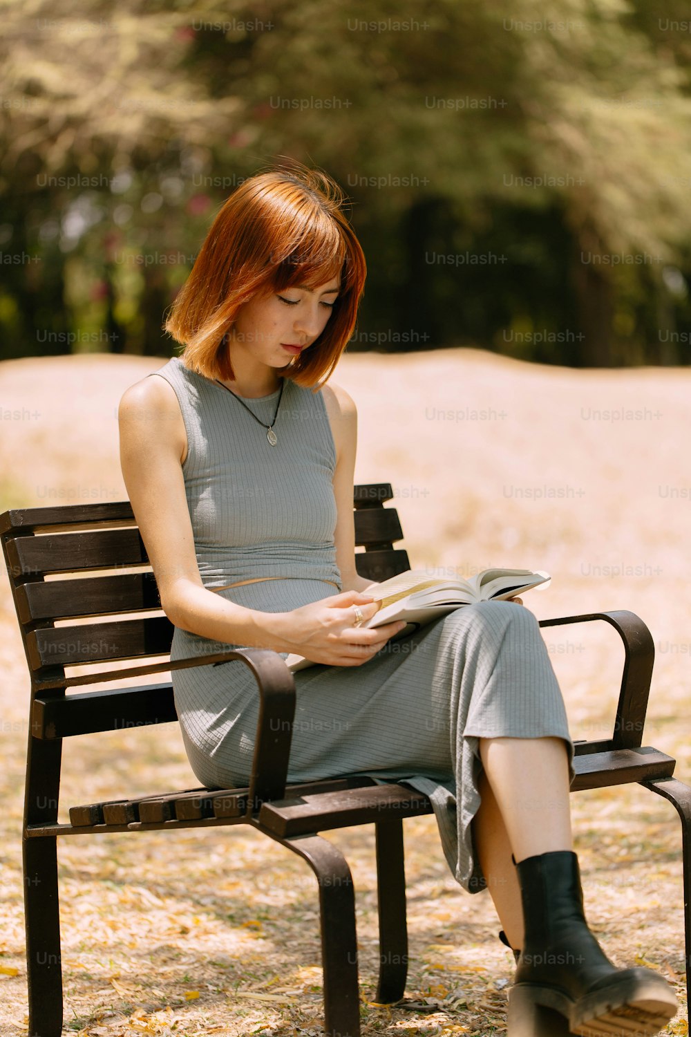 uma mulher sentada em um banco lendo um livro