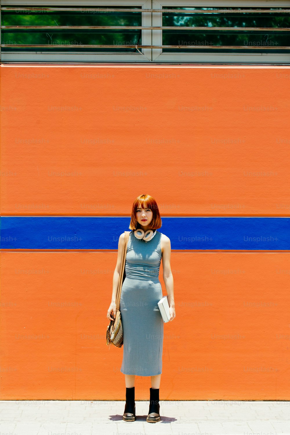 a woman standing in front of an orange and blue wall