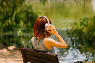 a woman sitting on a bench listening to music