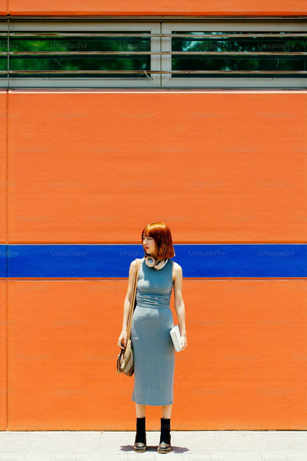 a woman standing in front of an orange wall