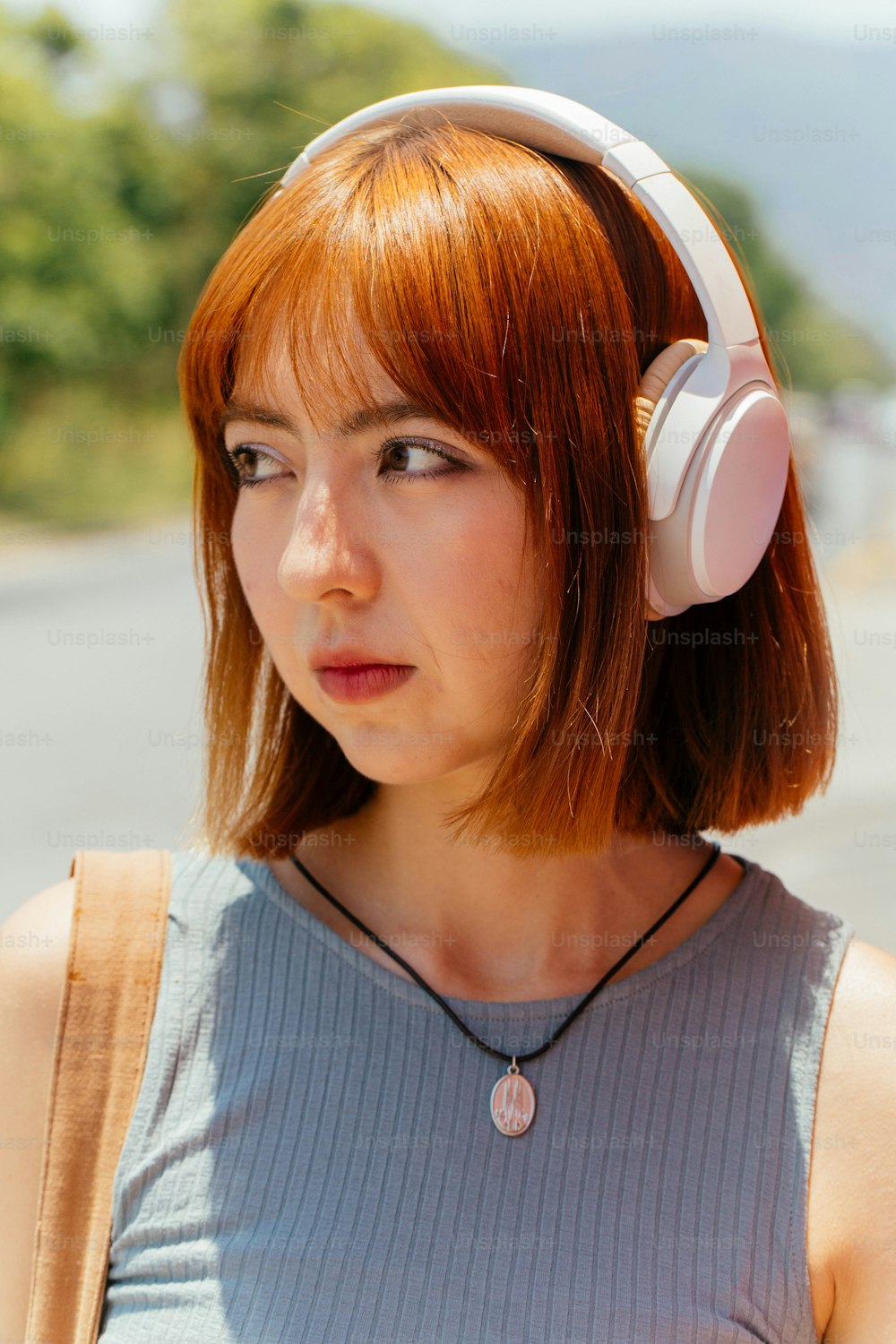 une femme aux cheveux roux portant une paire d’écouteurs