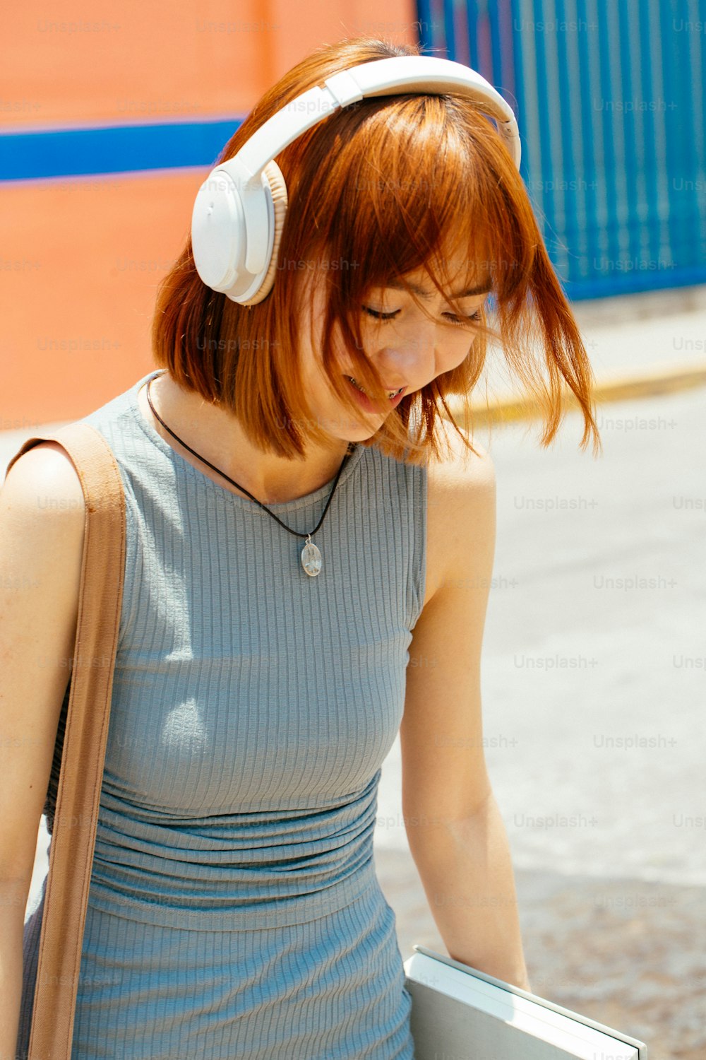a woman walking down a street with headphones on
