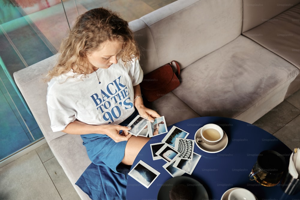 a girl sitting on a couch looking at photos