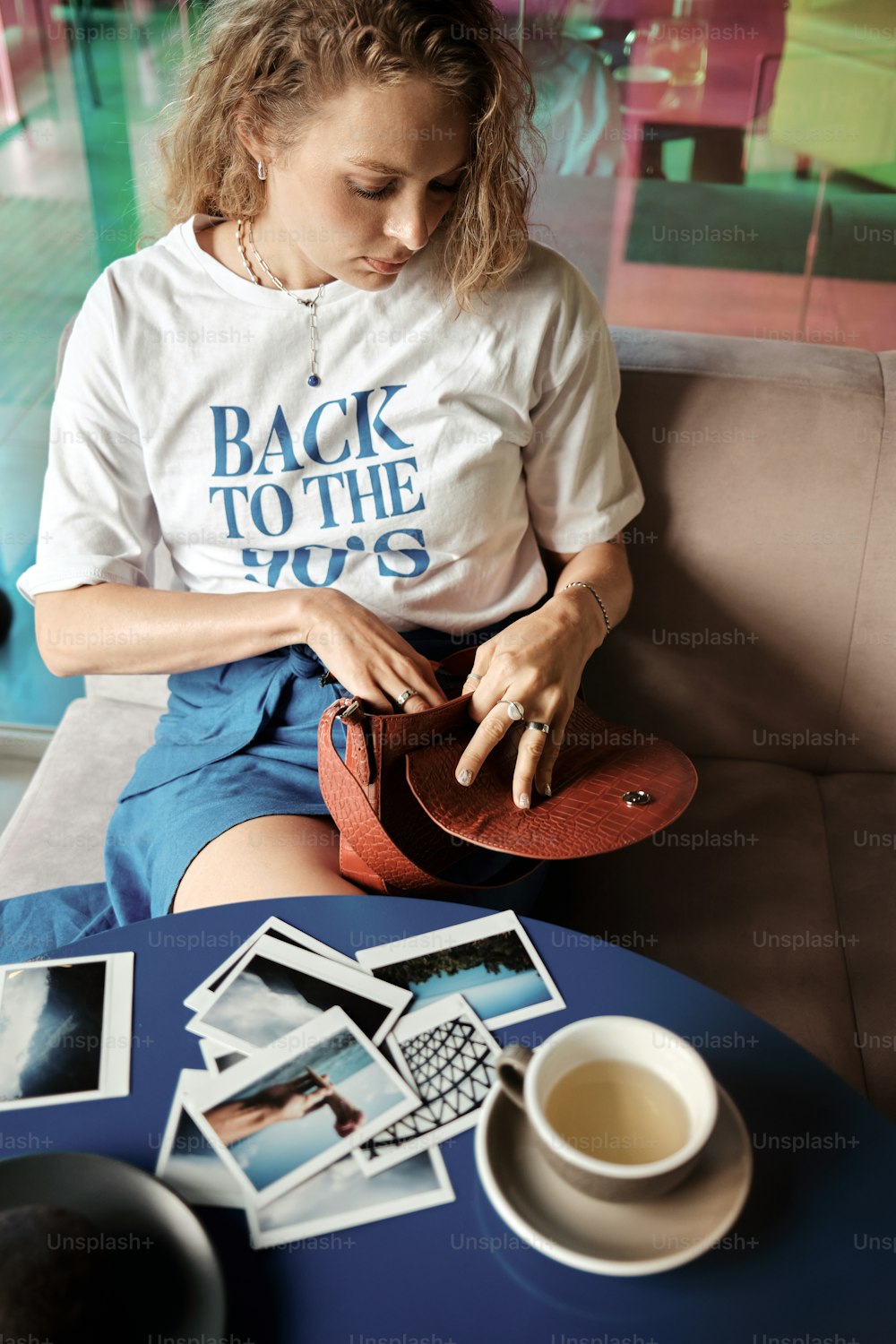 a woman sitting on a couch next to a cup of coffee