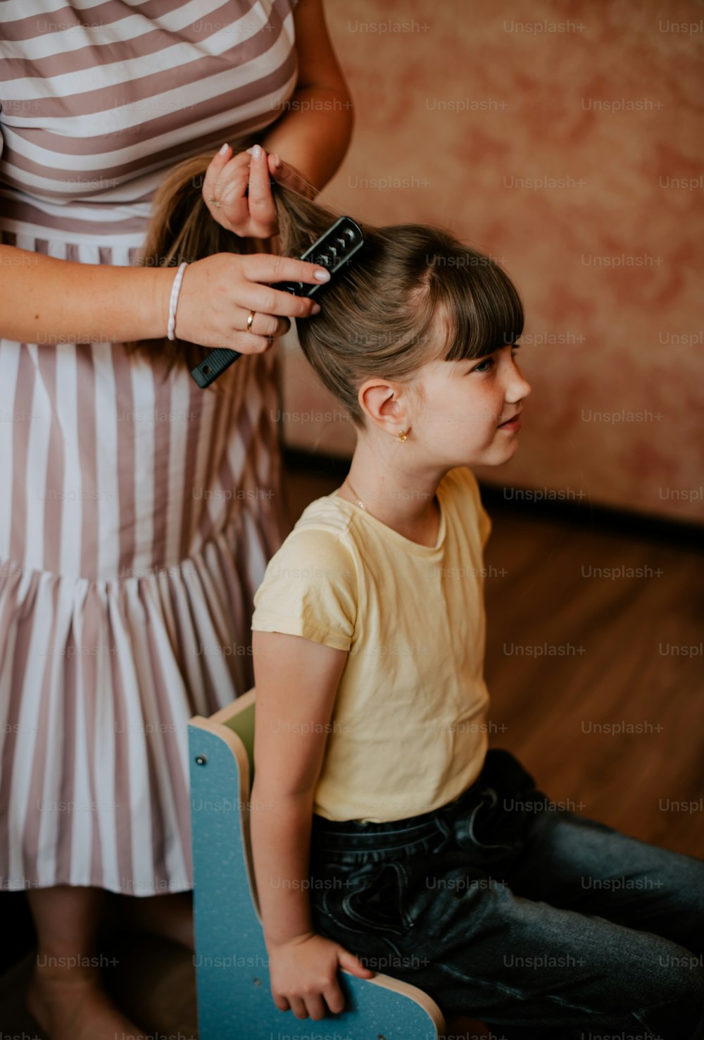 a little girl getting her hair cut by a woman